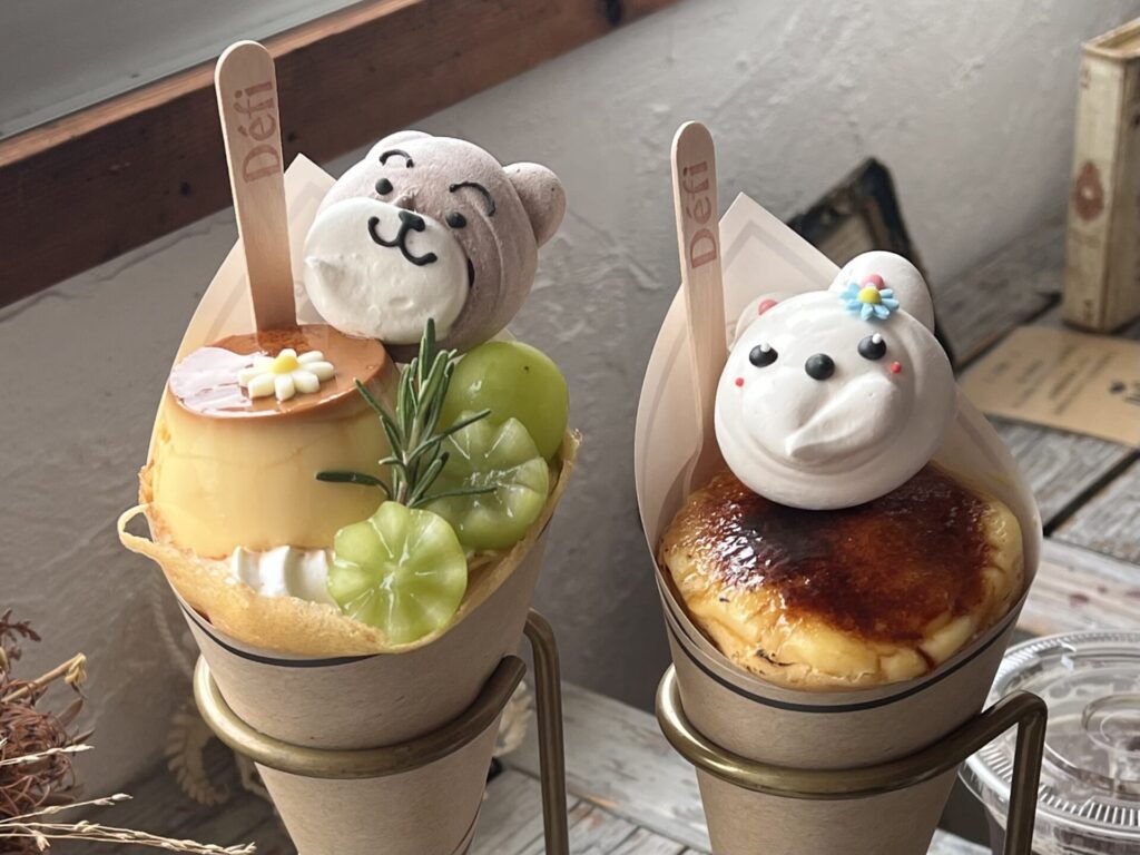 おいしいクレープの店 Defi のクレープ。クマとウサギの形のメレンゲクッキーをトッピングした、プリンやマスカット、ブリュレをのせた映えるクレープ2種