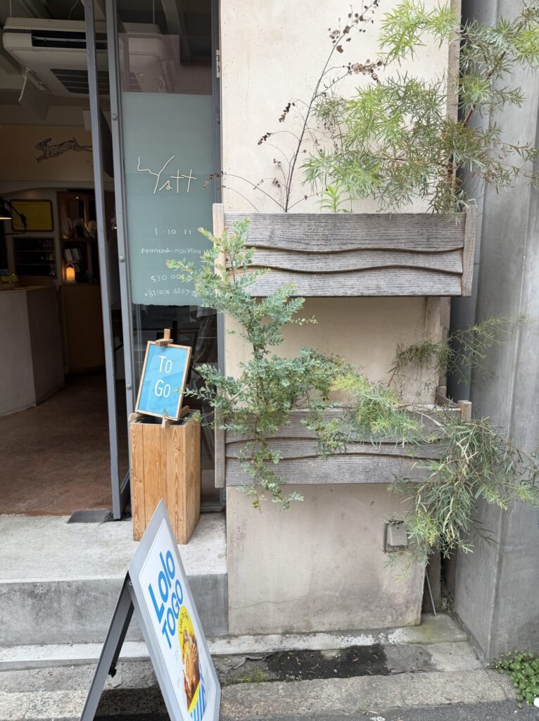 yatt 中崎町の外観(ガラス扉のロゴと植栽)