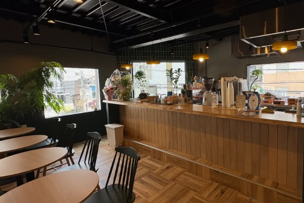 KiSSA RAY（喫茶レイ）の店内。木製カウンターとテーブル席、大きな窓から光が入る空間