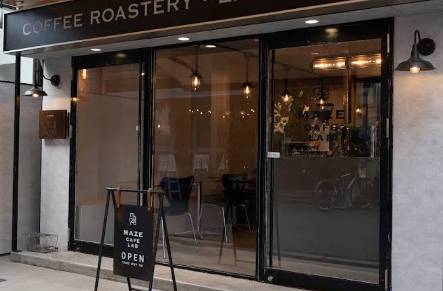 MAZE CAFE LABの外観。ガラス張りの入口と店名入りの立て看板